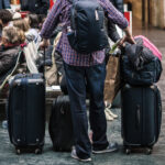 Homem segurando muitas malas no aeroporto (Foto: Unsplash/Tommaso Pecchioli)