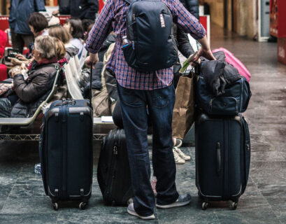 Homem segurando muitas malas no aeroporto (Foto: Unsplash/Tommaso Pecchioli)