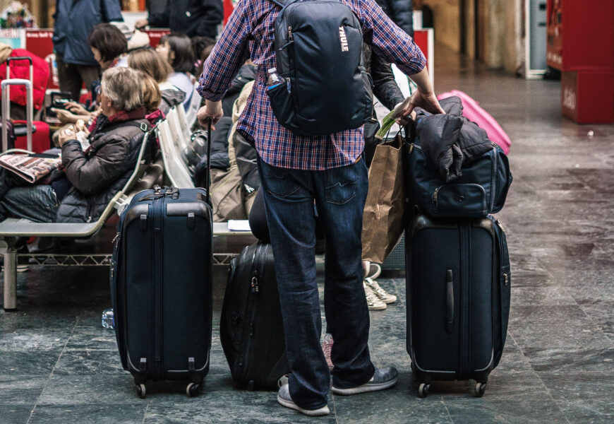 Homem segurando muitas malas no aeroporto (Foto: Unsplash/Tommaso Pecchioli)